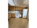 Functional kitchen featuring wood cabinetry, essential appliances and tile flooring at 106 Lakeside Ct, Oldsmar, FL 34677