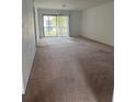 An empty living room with carpet floors and sliding glass doors to a private patio at 106 Lakeside Ct, Oldsmar, FL 34677