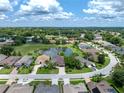 Aerial view of a home backing onto a pond, showcasing the property's peaceful setting and lush surroundings at 12333 Woodlands Cir, Dade City, FL 33525