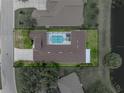 Aerial view showcasing the home's screened pool and outdoor living space in a serene setting at 12333 Woodlands Cir, Dade City, FL 33525
