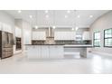 Spacious kitchen with stainless steel appliances, a large island, and sleek white cabinets at 21807 Amelia Rose Way, Land O Lakes, FL 34637
