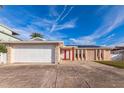 Single Gathering home featuring a two car garage, stone accents and a red front door at 3939 Rudder Way, New Port Richey, FL 34652