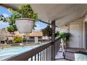 Balcony view overlooking a community pool and landscaped grounds, enhanced with hanging plants at 6308 Newtown Cir # 8C5, Tampa, FL 33615