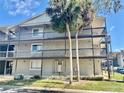 Exterior of a three-story condo building with balconies and palm trees, showcasing its architectural style at 6308 Newtown Cir # 8C5, Tampa, FL 33615