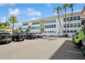 Beautiful exterior of building with ample parking and manicured landscaping with palm trees at 661 Poinsettia Ave # 307, Clearwater Beach, FL 33767