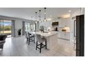 Bright, open kitchen featuring a spacious island, white cabinetry, and modern lighting at 7528 Paradiso Dr, Apollo Beach, FL 33572