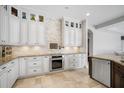 A spacious kitchen is designed with cream cabinets, a stylish backsplash, and granite countertops at 11505 Heron Hills Ln, Riverview, FL 33569