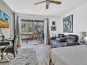 Cozy bedroom featuring a gray reclining sofa, a desk, and sliding doors leading to a balcony at 3106 Bayshore Oaks Dr, Tampa, FL 33611
