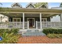 Inviting front porch featuring classic columns, a brick pathway, and a cozy seating area at 3115 W Fair Oaks Ave, Tampa, FL 33611