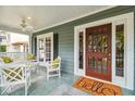 Close-up of the inviting front porch featuring a ceiling fan, a swing, and a 'hello' welcome mat at 3115 W Fair Oaks Ave, Tampa, FL 33611