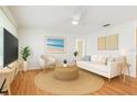 Bright living room with modern decor, including a white sofa and light hardwood floors at 349 Shirley Ave, Belleair, FL 33756