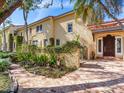 Inviting home exterior with brick pathway, mature trees, lush greenery, and decorative lion statue at 5020 S Shore Crest Cir, Tampa, FL 33609