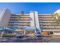 Exterior shot of a modern multi-story building boasting a covered parking area and beautiful landscaping at 7902 Sailboat Key S Blvd # 206, South Pasadena, FL 33707