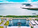 Exterior shot of beachfront condos featuring beautiful views of clear blue seas on a sunny day at 9 Forbes Pl # 206, Dunedin, FL 34698