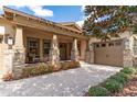 Inviting front exterior showcasing a charming porch with stone accents and a beautiful brick driveway at 15944 Ternglade Dr, Lithia, FL 33547