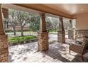 Spacious front porch with stone columns, brick pavers, and comfortable seating area at 15944 Ternglade Dr, Lithia, FL 33547