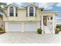 Two-story waterfront home featuring a covered entry, 2-car garage, and brick paved driveway at 3487 Amberjack Dr, Hernando Beach, FL 34607