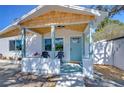 Inviting front porch with chairs, light blue accents and a hello door mat that offers a welcoming touch at 5731 17Th S Ave, Gulfport, FL 33707