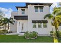 Contemporary home with a white exterior and dark awnings over the windows at 902 W Sligh Ave, Tampa, FL 33604