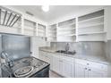 Bright kitchen featuring white cabinetry, a stainless steel sink, and plenty of shelf storage at 2169 22Nd N Ave, St Petersburg, FL 33713