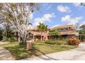 Elegant two-story home with a well-kept lawn, mature trees, and a stylish exterior at 2965 Eagle Estates E Cir, Clearwater, FL 33761