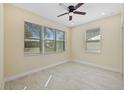 A bright room with large windows, neutral walls and flooring and a ceiling fan at 4006 N 27Th St, Tampa, FL 33610