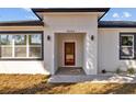 Inviting entrance with a red front door, modern lighting and meticulously maintained landscaping at 4006 N 27Th St, Tampa, FL 33610
