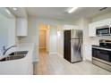 Bright kitchen with white cabinets, stainless steel appliances, and tile flooring at 5043 Escalante Dr, North Port, FL 34287