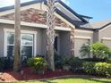 Charming home entrance with stone accents, lush landscaping, and healthy green lawn at 6440 Dutton Dr, Wesley Chapel, FL 33545