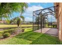 View of the screen enclosed lanai, pond, and trees, showing the depth of the backyard at 5062 Stone Harbor Cir, Wimauma, FL 33598