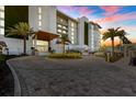 A modern building with lush landscaping and palm trees creates a tropical oasis at 1020 Sunset Point Rd # 703, Clearwater, FL 33755