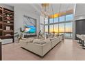 Open-concept living room boasts high ceilings, waterfront views, and a large sectional sofa for gathering at 1020 Sunset Point Rd # 703, Clearwater, FL 33755