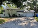 Two-story home with an attached garage and landscaped yard at 14803 Tulip Dr, Tampa, FL 33613
