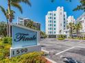 Exterior signage showing the address of the Finale condominiums amidst lush landscaping and a clear blue sky at 1590 Gulf Blvd # 501, Clearwater Beach, FL 33767