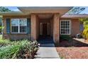 Inviting front entrance with brick facade, tiled entryway, and decorative landscaping at 603 S Sylvan Dr, Brandon, FL 33510