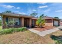 Brick home features an attached garage, and well-maintained landscaping at 603 S Sylvan Dr, Brandon, FL 33510