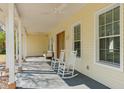 Covered porch featuring classic architectural details and comfortable seating on a sunny day at 6615 Ridge Top Dr, Trinity, FL 34655