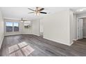Bright living room with lots of windows, ceiling fans, and gray wood-look flooring at 7086 Chatum Light Run, Bradenton, FL 34212