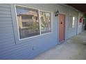 Exterior shot of the side of a condo unit, painted gray with an orange door and a lantern-style light at 10263 Gandy N Blvd # 105, St Petersburg, FL 33702