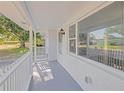Inviting covered porch offers a charming outdoor seating area with view of neighborhood at 1140 7Th Ne Ave, Largo, FL 33770