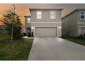 Charming two-story home featuring a two-car garage and well-maintained front yard at dusk at 16126 Sunday Stroll Way, Odessa, FL 33556