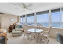 Bright sun room with water view, ceiling fan, and dining table at 1868 Shore S Dr # 602, South Pasadena, FL 33707