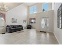 Bright living room featuring high ceilings, tiled floors, contemporary furnishings, and a decorative front door at 20115 Nob Oak Ave, Tampa, FL 33647