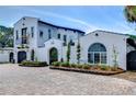 Stunning white home with unique architecture, featuring an arched entryway and well-manicured landscaping at 2113 S West Shore Blvd, Tampa, FL 33629