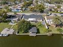 Waterfront home featuring a wooden dock, boat, and covered lanai overlooking the waterfront at 2146 Society Dr, Holiday, FL 34691