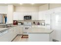 Well-lit kitchen with white cabinetry, tile flooring, modern appliances, and center island at 2250 Long View Cir, Brooksville, FL 34604