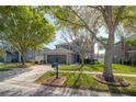 Charming two-story home features a well-manicured lawn, mature trees, and a two-car garage, offering great curb appeal at 3025 Chessington Dr, Land O Lakes, FL 34638
