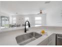 Bright, open kitchen with quartz counters and stainless steel sink overlooking the living and dining spaces at 3025 Chessington Dr, Land O Lakes, FL 34638