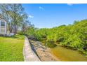 Idyllic backyard view with lush greenery, a serene canal, and a charming walkway at 3042 Branch Dr, Clearwater, FL 33760
