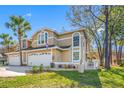 Beautiful tan home with a well-maintained lawn, and a large driveway and a garage at 3042 Branch Dr, Clearwater, FL 33760